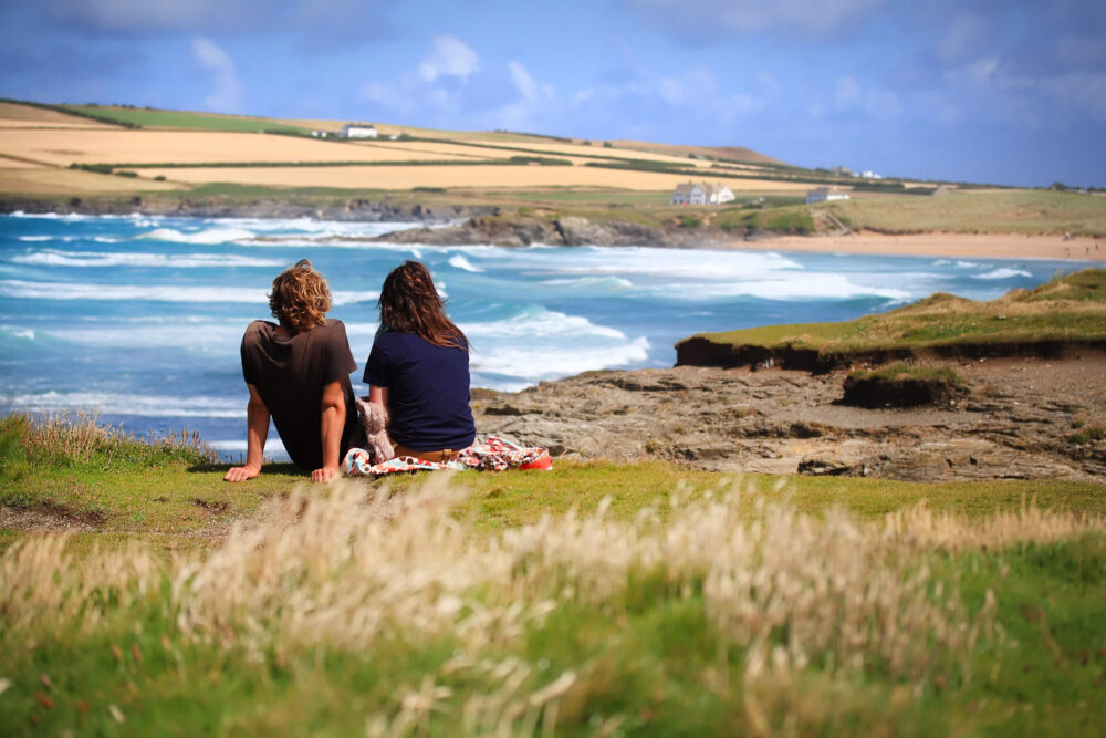 Couple sitting looking at the sea - couples breaks