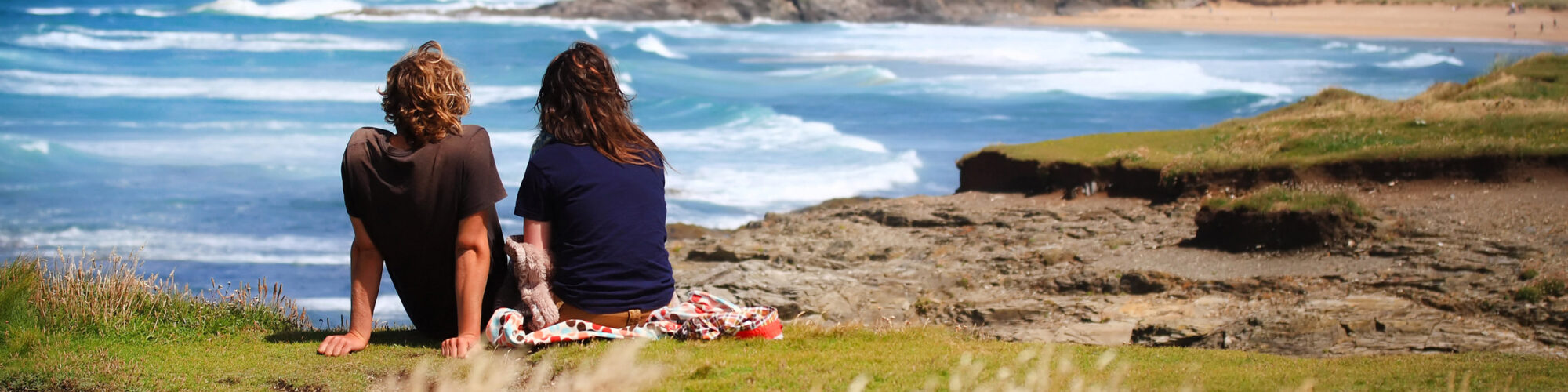 Couple sitting looking at the sea - couples breaks