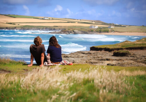 Couple sitting looking at the sea - couples breaks